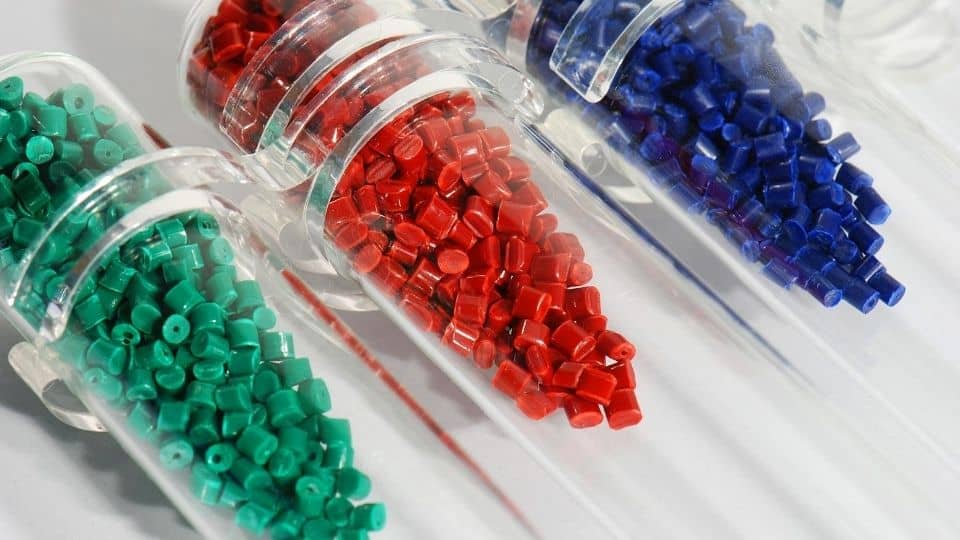 Dyed polymer resin in test-tubes in labortory, nurdles, small plastic pellets